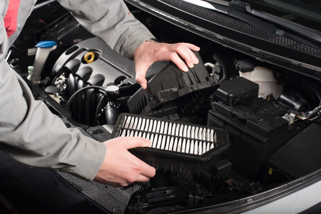 Mechanic changing the air filter on a car royalty free image